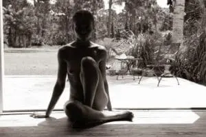 Silhouette of a person sitting on floor.