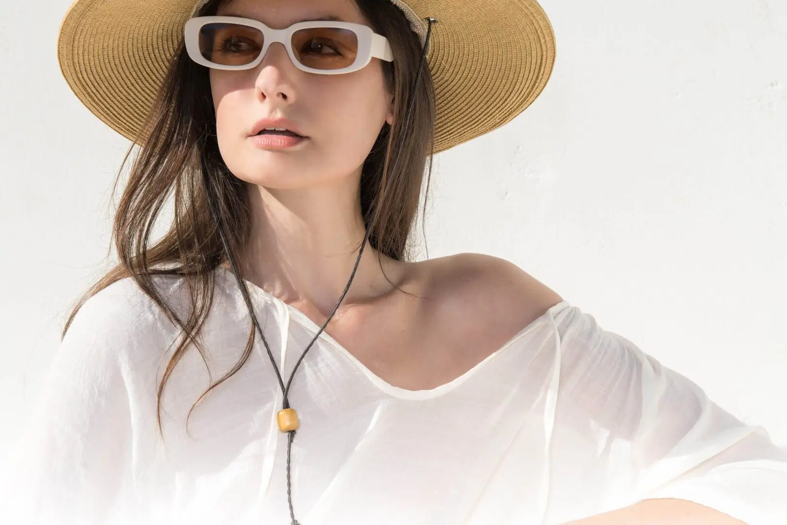 Woman in sun hat and white sunglasses.