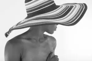 Woman in large striped sunhat, bare shoulders
